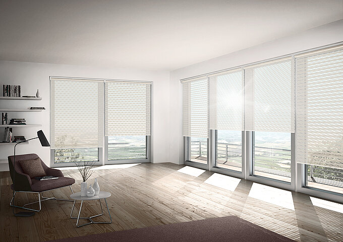 Helles Wohnzimmer mit Doppelrollos vom Typ „Loki“ mit wellenförmigem Muster, die viel Tageslicht durchlassen und gleichzeitig Sichtschutz bieten.