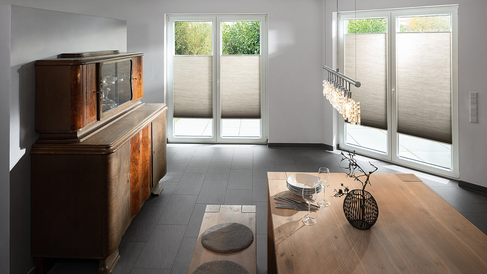 Helles Esszimmer mit halbhohen, naturfarbenen MHZ Wabenplissees an bodentiefen Fenstern.