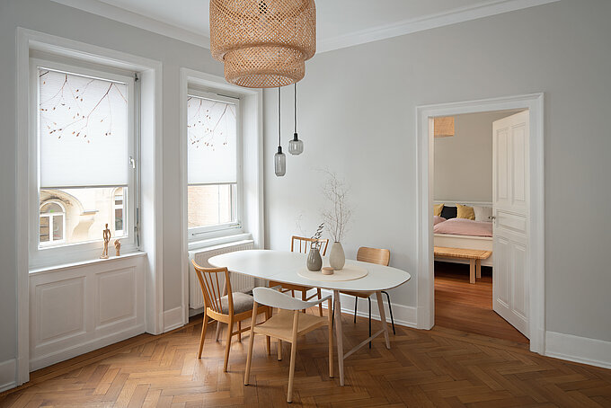 Esszimmer mit zwei Fenstern und weißen Wabenplissees mit zartem Naturmotiv, modern und hell eingerichtet