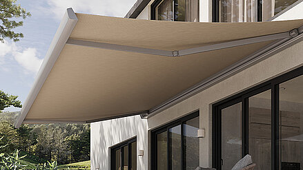Beige Gelenkarmmarkise an der Terrasse eines modernen Hauses mit Blick ins Grüne.