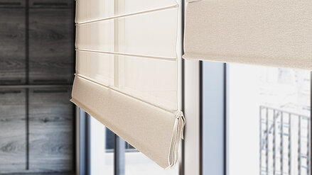 Helles Raffrollo aus Stoff vor einem Fenster mit Blick auf einen Balkon, teilweise hochgezogen.