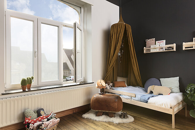 Bright children’s room with a window covered by privacy adhesive textile.
