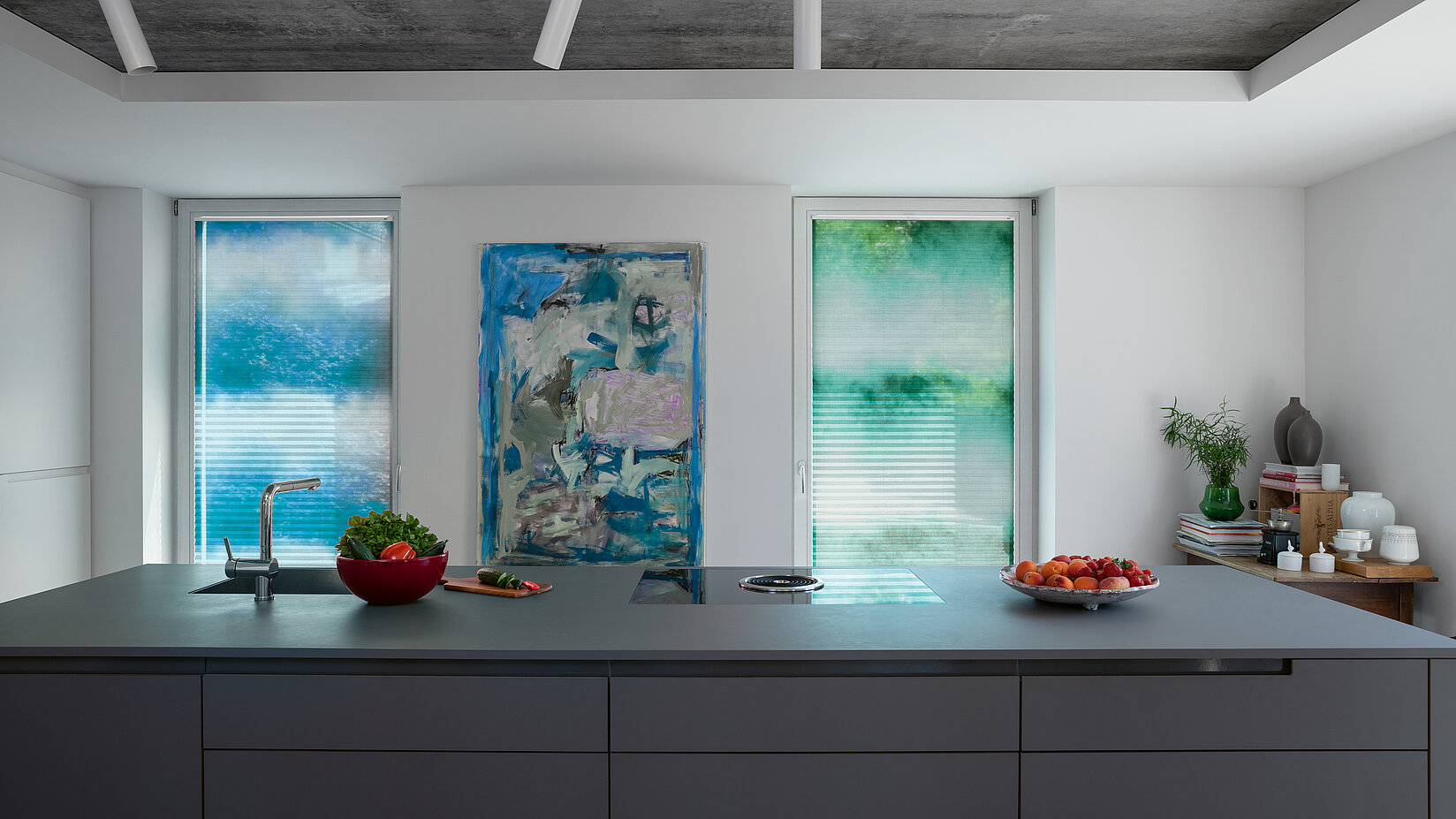 Modern kitchen with tall windows and pleated blinds in green and blue watercolour design.