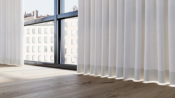 Weiße, lichtdurchlässige MHZ-Vorhänge vor großen Fenstern mit Blick auf Stadthäuser und hellem Holzboden.