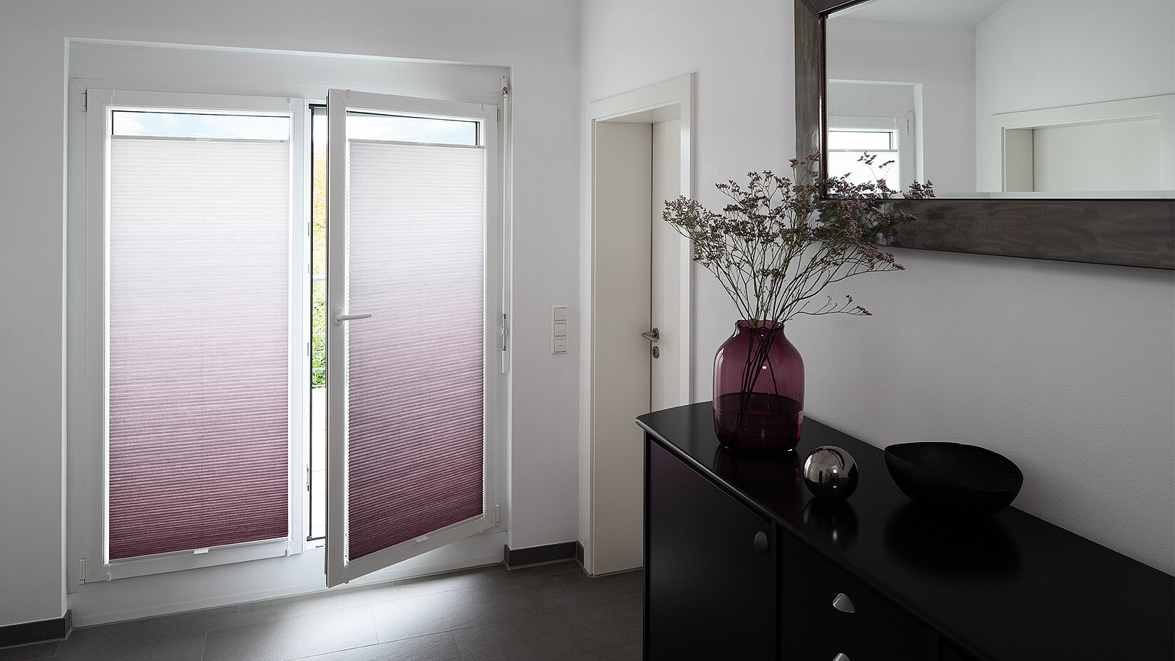 MHZ Wabenplissees mit Farbverlauf in Lila-Weiß an zwei Terrassentüren in einem modernen Flur mit schwarzer Konsole.