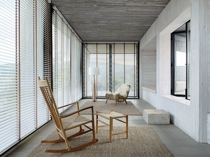 Bright room with wooden blinds, rocking chair, and natural Scandinavian-style furnishings.